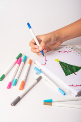 School supplies, teenager's hand drawing with markers, white background, selective focus.