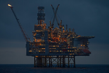 Early morning panoramic view of drilling rig, with dark blue sky in the deep blue ocean.