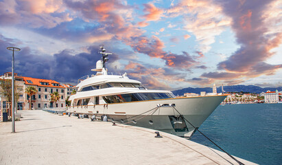 Pleasure ship on the sea waves. The yacht is moored to the shore in the port.