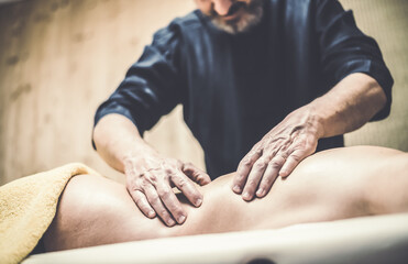 Soft focus view of man massaging a woman in a wellness center Oiled hands on a body relaxing the muscles and relieve tension  .Holistic exercise for calm and clear your mind. Health well-being concept - obrazy, fototapety, plakaty