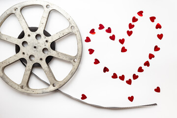 Love story movie concept. Film reels with red hearts, top view