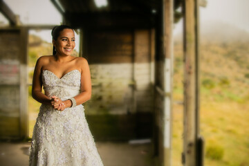 joven mujer latina sonriendo feliz y mirando a un lado con su vestido de novia