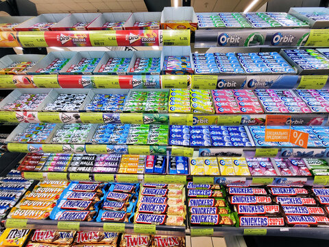 Minsk, Belarus. Oct 10, 2022. Various candies, chewing gum, chocolate bars on the store shelf in grocery store. Orbit, Dirol chewing gums. Halls candy. Snickers, Bounty candy bars. Mobile photo
