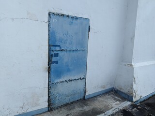 Rusty blue iron door commonly used in old textile factories