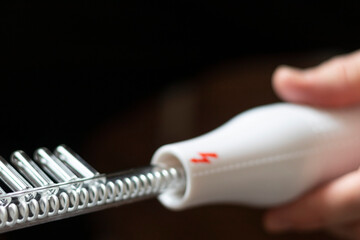 Close up shot of the high frequency comb tool for hair and scalp treatment. Healthcare