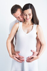 Fototapeta premium Young man and pretty pregnant woman hugging together