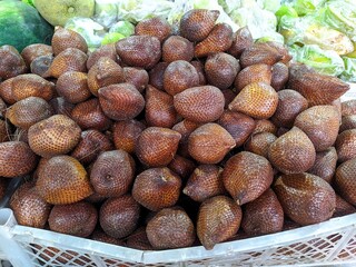 Salak (Salacca zalacca) - Large amounts of snake fruit. Fresh snake fruit on the wood. Thorny Palm