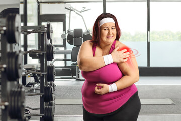 Woman in a gym suffering from shoulder pain