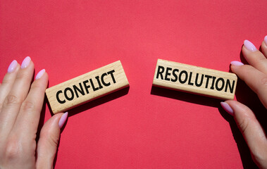 Conflict or Resolution symbol. Concept word Conflict or Resolution on wooden blocks. Businessman hand. Beautiful red background. Business and Conflict or Resolution concept. Copy space