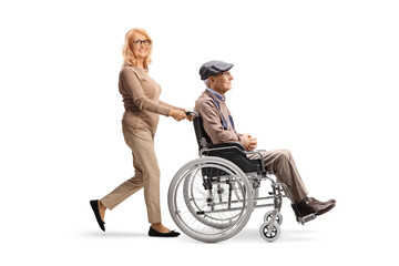 Woman pushing a senior man in a wheelchair - obrazy, fototapety, plakaty