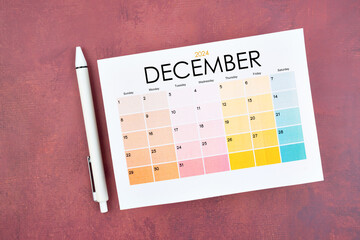 December 2024 calendar page and pen on retro background.