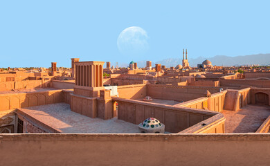 Historic City of Yazd with famous wind towers in the background full moon at sunset - Yazd, iran...