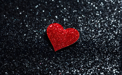 Fototapeta premium A small red heart on a sparkling black background. Generative AI