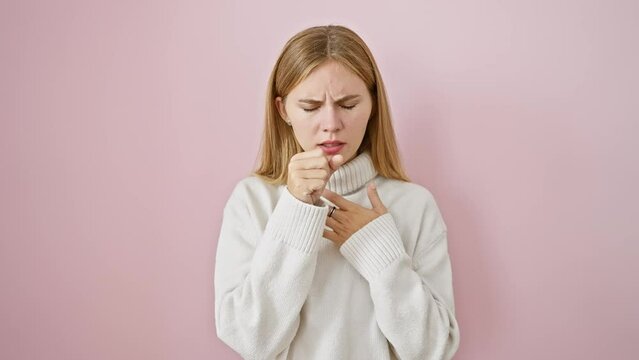 Unwell blonde girl battling cold or bronchitis, coughing while standing over pink isolated background. attractive female in winter sweater showing distressing health care issue.