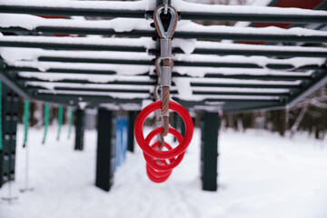 Red rings on the playground during snowfall in winter.