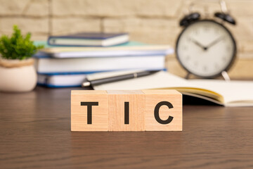 the word TIC formed from wooden blocks suggests a concept related to technology, innovation, and...