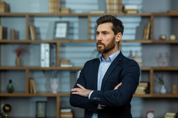 Fototapeta premium A seasoned professional stands with poise in his elegant office, exuding confidence as he ponders business strategies.