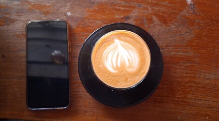 coffee and smartphone on wooden table. Shot from top view