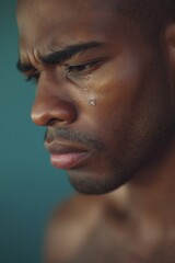 Fototapeta premium Young Man with Tear Drops on Face Showing Sadness and Emotion
