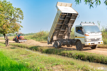 A dump truck spreads gravel on the road to allow.