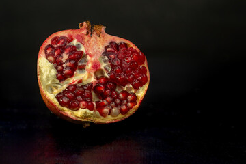 Half of a pomegranate on a black background.
