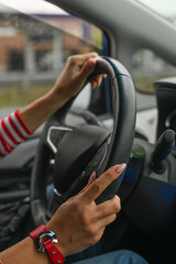 a woman is driving a car. women's hands on the steering wheel.