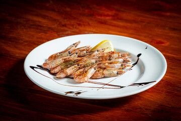 Boiled shrimp with lemon. On a wooden table.