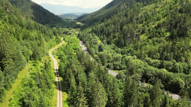 Group of cyclists team ride down gravel mountain road in Slovakia next to a highway. Cycling on gravel roads or off-road. Friends on bikes ride together have fun outdoors. Riding in Mountain region