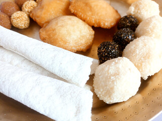 Assamese traditional food items like pitha, laddu, doi sira with assamese gamosa background with japi motifs
