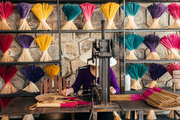  a woman is making incense sticks from sandalwood 