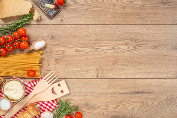 Italian food background pasta, spaghetti, tomatoes, parmesan olives and basil on a wooden background. top view. copy space