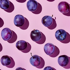 Flat lay of plums on a pastel pink background.Minimal concept.