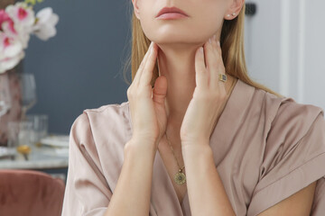 Caucasian woman touching her throat. Sore throat, cold, flu, tonsillitis or thyroid gland problem