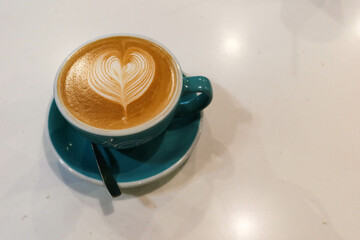 cafe latte with heart shaped coffee art in a blue cup