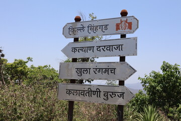 Signboard on Sinhagad Fort in Pune mentioning Fort name, a place to see nature, open theater