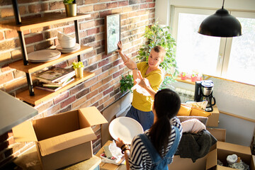 Young lesbian couple decorating new kitchen at home