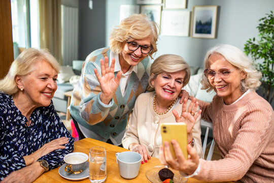 Senior women taking group photo at home