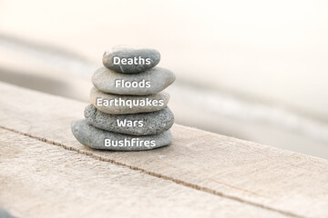 Deaths, Floods, Earthquakes, Wars and Bushfires. Disasters concepts writing on the stones