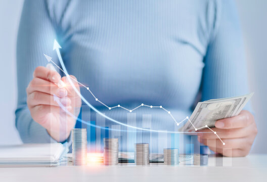 Businesswoman plans yearly business growth, goals, with virtual holographic charts Calculate investment income and profit and add it with positive growth indicators, stocks, profits.