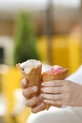 Couple enjoying ice cream scoops in waffle cups outdoors in summer