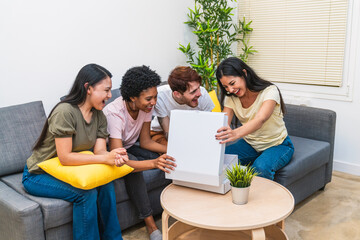 Fototapeta premium Diverse friends sharing the joy of opening a pizza box together in a comfortable living room, smiling and enjoying the moment