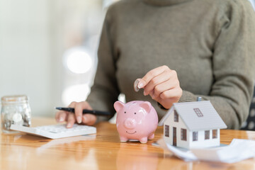  hand of businesswoman, putting money coin into piggy bank for saving money. saving money and...