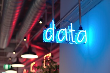data blue neon glowing sign on minimal wall in the it company office or coworking