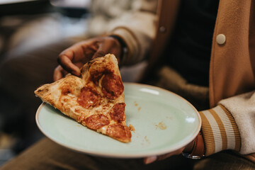 Close up photo of a man about to enjoy and eat the last slice of pizza.