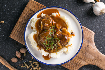 delicious meatballs on hot potato puree with cheese sauce on background view from above close-up