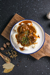 delicious meatballs on hot potato puree with cheese sauce on background view from above close-up