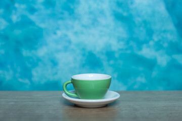 Coffee cup on wooden table and blue wall background, stock photo