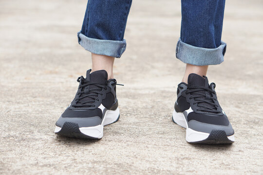 Close up male teenager wears sneakers shoes and blue jeans legs. Concept, fashion, lifestyle. Comfortable footwears and costumes for going out, journey or traveling. cool casual fashion for teens   
