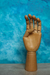 Wooden hand on a blue background. 