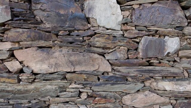 Detailed shot: Rural stone wall crafted from rocks and mud, Uttarakhand, India. Countryside construction.
